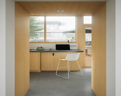 Home office desk positioned perpendicular to a large window to avoid glare