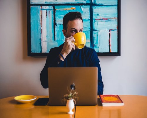 Colombian office worker taking a break and drinking coffee
